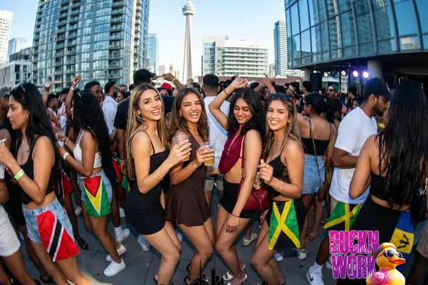 Costumed masqueraders and soca music trucks moving along the Caribana Grand Parade route on Lake Shore Boulevard in Toronto